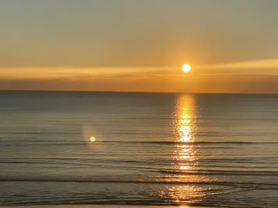 a sunset over the ocean with the sun setting at Ithaki Phinikoudes Apartment No. 102 in Larnaka
