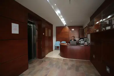 a man sitting at a desk in an office with a laptop at Ithaki Phinikoudes Apartment No. 102 in Larnaka