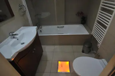 a bathroom with a sink and a tub and a toilet at Ithaki Phinikoudes Apartment No. 105 in Larnaka