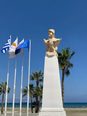 a statue on the beach next to some flags at Ithaki Phinikoudes Apartment No. 105 in Larnaka