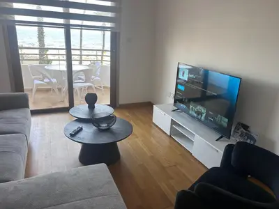 a living room with a couch and a flat screen tv at Ithaki Phinikoudes Apartment No. 202 in Larnaka