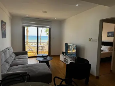 a living room with a couch and a television at Ithaki Phinikoudes Apartment No. 202 in Larnaka
