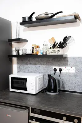 a kitchen counter with a microwave and a coffee maker at Hubstay - Klea's Downtown City Apartment Suite in Larnaka