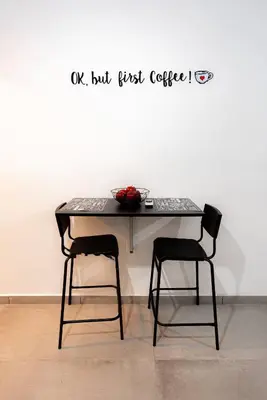 a table with two chairs in front of a wall at Hubstay - Klea's Downtown City Apartment Suite in Larnaka