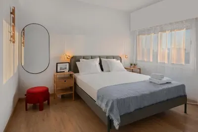 a bedroom with a large bed and a red chair at Amazing Sea View and Location in Scala