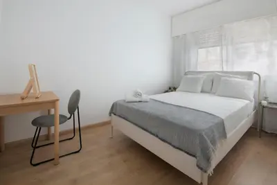 a white bedroom with a bed and a desk at Amazing Sea View and Location in Scala