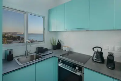 a kitchen with blue cabinets and a sink and a window at Amazing Sea View and Location in Scala