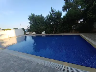 a swimming pool with blue water in a yard at Amazing Sea View and Location in Scala