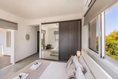 a living room with a couch and a large mirror at Ayia Napa Bay View Villa 5 in Ayia Napa