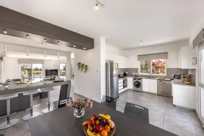 a kitchen with a table with a bowl of fruit on it at Ayia Napa Bay View Villa 5 in Ayia Napa