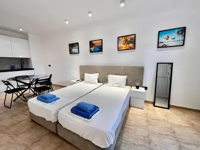 a bedroom with a large bed and a table at STAY Napa Velvet Apartment in Ayia Napa