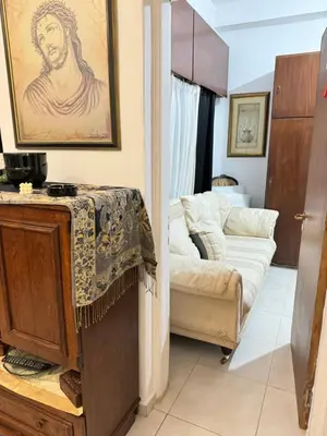 a living room with a couch and a painting on the wall at Διαμέρισμα ισόγειο για ενοικίαση in Limassol