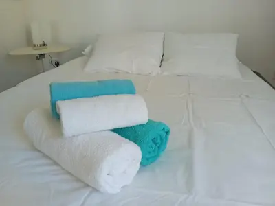 a white bed with towels on top of it at Green Door 3bdr flat City Centre in Nicosia