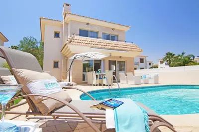 a villa with a swimming pool in front of a house at Sonja in Paralimni
