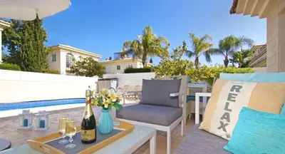 a patio with a table and a chair and a pool at Sonja in Paralimni