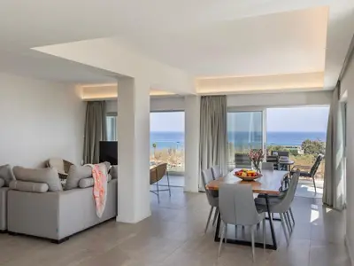a living room with a table and a couch at Emerald Bay Sea-Front Penthouse in Protaras