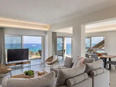 a living room with a couch and a television at Emerald Bay Sea-Front Penthouse in Protaras