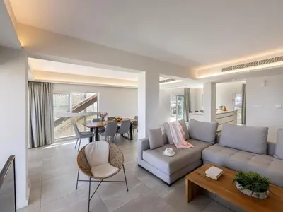 a living room with a couch and a table at Emerald Bay Sea-Front Penthouse in Protaras