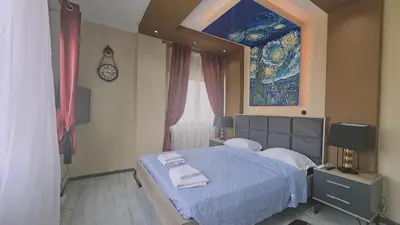 a bedroom with a bed and a window with a painting at STAY Van Gogh Apartment in Larnaka
