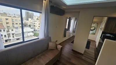 a living room with a couch and a large window at STAY Van Gogh Apartment in Larnaka