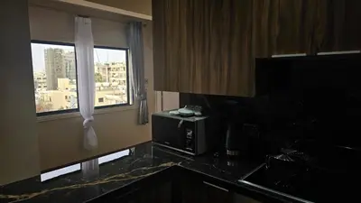 a kitchen with a view of a city from a window at STAY Van Gogh Apartment in Larnaka