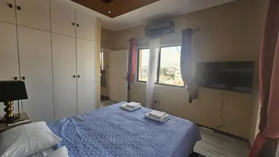 a bedroom with a blue bed and a window at STAY Van Gogh Apartment in Larnaka