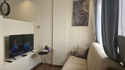 a living room with a couch and a tv at STAY Van Gogh Apartment in Larnaka
