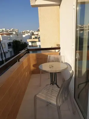 a small table and a chair on a balcony at Studio In the Centre of the city in Ayia Napa