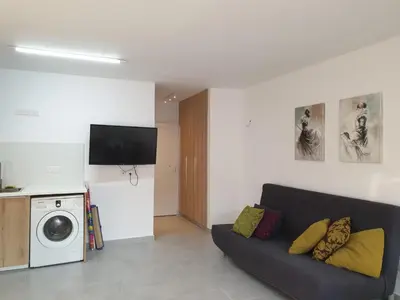 a living room with a couch and a washing machine at Studio In the Centre of the city in Ayia Napa