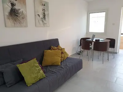 a living room with a couch and a table with a laptop at Studio In the Centre of the city in Ayia Napa