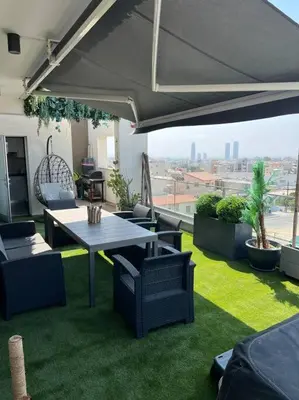a patio with a table and chairs and an umbrella at 3 Br Penthouse Jacuzzi Seaview in Limassol