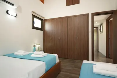 a bedroom with a blue bed and wooden cabinets at Villa Evia - Walking to Med Sea in Ayia Napa