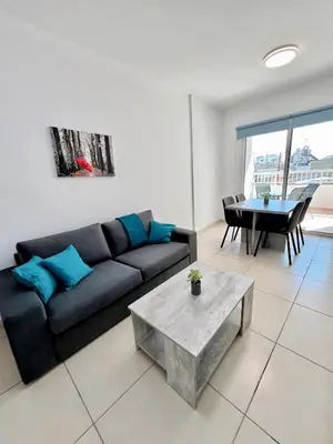 a living room with a black couch and a table at Georgiou 202 in Larnaka