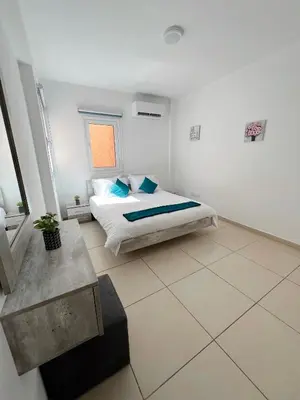a white bedroom with a bed and a window at Georgiou 202 in Larnaka