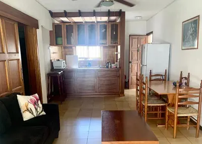 a living room with a couch and a table and a kitchen at Sandy Beach Villas Sea View Apartment Pyla in Larnaka