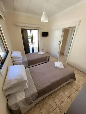 two beds are in a room with a window at Ayia Napa Marina Luxury Villas - Pearl in Ayia Napa