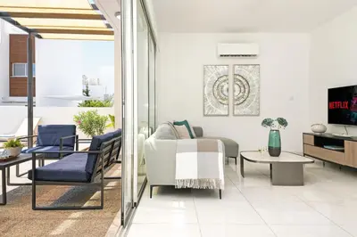 a living room with a couch and a table at Villa Rosaleen - Ayia Napa Resort Center in Ayia Napa