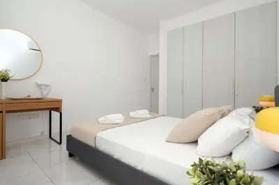 a bedroom with a bed with a mirror and a table at Villa Rosaleen - Ayia Napa Resort Center in Ayia Napa