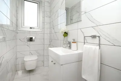a white bathroom with a sink and a toilet at Villa Evelin - Ayia Napa Resort Center in Ayia Napa