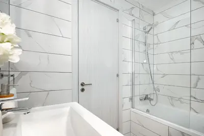 a white bathroom with a tub and a shower at Villa Evelin - Ayia Napa Resort Center in Ayia Napa
