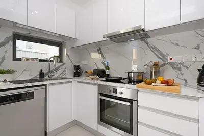 a kitchen with white appliances and a cutting board with fruit at Villa Merope - 3Bed All En-suite in Paralimni