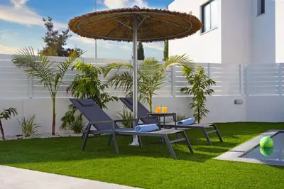 a patio with two chairs and an umbrella at Villa Merope - 3Bed All En-suite in Paralimni