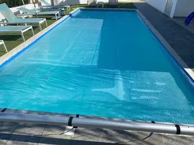 a large blue swimming pool with chairs in it at Akefalou Bay Villa in Protaras