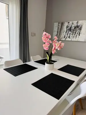 a dining room table with black and white mats at Sea view 3 bedrooms apartment in Limassol