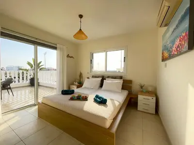a bedroom with a bed and a large window at Star Apt in front Nissi whit Sea View in Ayia Napa