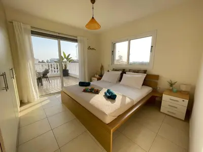 a bedroom with a bed and a large window at Star Apt in front Nissi whit Sea View in Ayia Napa