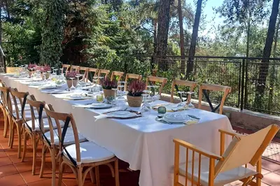 a long table with white table cloth and wooden chairs at Paradise Peek, Platres in Platres