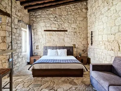 a bedroom with a bed in a stone wall at Andre Marie Stonewood Retreat in Limassol