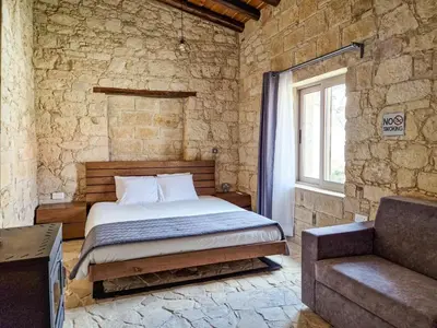 a bedroom with a bed in a stone wall at Andre Marie Stonewood Retreat in Limassol