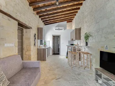 a living room with a couch and a kitchen at Andre Marie Stonewood Retreat in Limassol